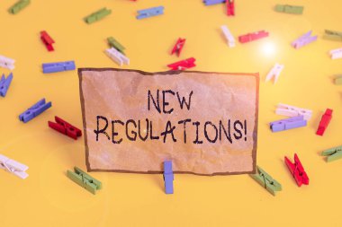 Yeni Yönetmelikler 'in el yazısı metinleri. Kural kavramının anlamı, hükümetin bir şeyi kontrol etmesini sağladı. Renkli çamaşır iğnesi kağıtları boş hatırlatıcı sarı zemin arka plan ofisi..