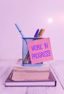 Kelime yazma çalışmaları devam ediyor. Tamamlanmamış projeler için iş konsepti. Yığılmış kitaplara eklenen ya da geliştirilen kitap. Kalem tutacağı yapışkan not..