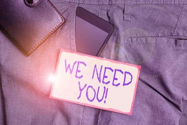 El yazısı: "Sana ihtiyacımız var". Kavram, birinden belirli bir iş için birlikte çalışmasını ya da cebinde cüzdan ve kağıt bulunan akıllı telefon cihazını hedef almasını istemektir.. — Stok fotoğraf
