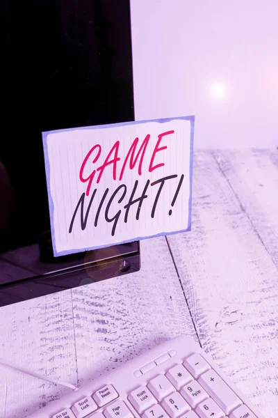 Psát text Game Night. Koncept znamená obvykle jeho volal na dospělých hrát data jako poker s přáteli Zápis papír přilepený na černém monitoru počítače obrazovky v blízkosti bílé klávesnice. — Stock fotografie
