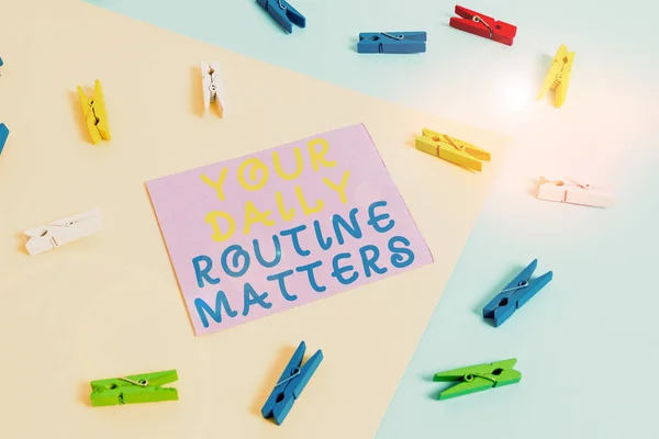 Conceptual hand writing showing Your Daily Routine Matters. Business photo showcasing practice of regularly doing things in fixed order Colored clothespin paper reminder with yellowblue background.