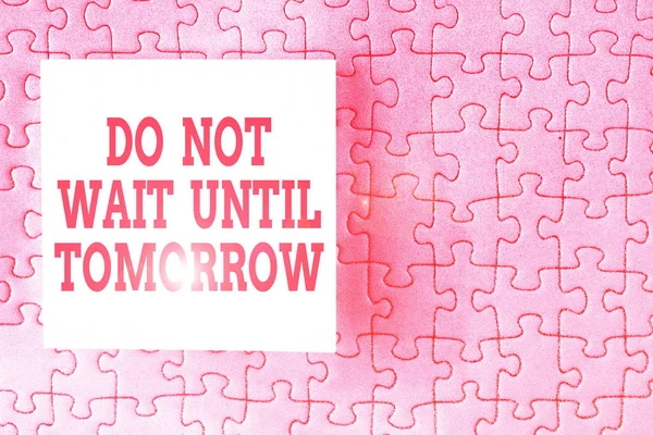 Text sign showing Do Not Wait Until Tomorrow. Conceptual photo needed to do it right away Urgent Better do now Piece of square note paper use for give notation stick to puzzle background.