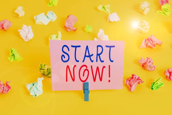 Conceptueel handschrift met Start Now. Zakelijke foto presentatie aarzel niet om te werken of dingen te doen meteen Gekleurd verfrommeld papier lege herinnering witte vloer wasknijper. — Stockfoto