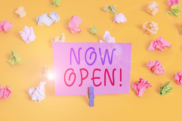 Conceptual hand writing showing Now Open. Business photo showcasing leave door or windows not closed or barred at this current time Colored crumpled paper empty reminder white floor clothespin.