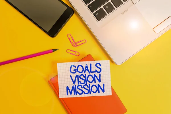 Conceptual hand writing showing Goals Vision Mission. Business photo showcasing practical planning process used to help community group Laptop smartphone clip pencil paper sheet colored background. — Stock Photo, Image