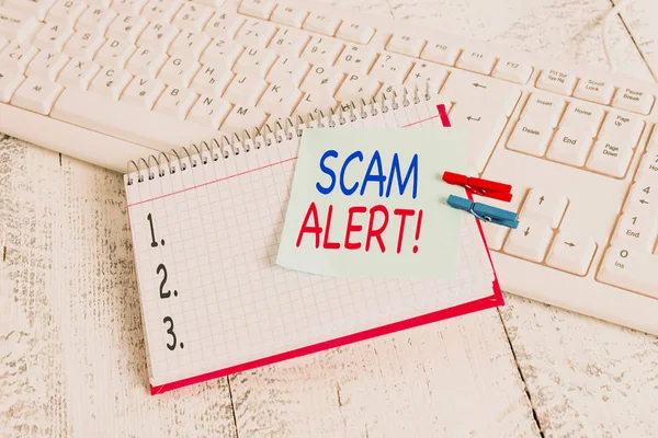 Scrivere testo Scam Alert. Concetto significato fraudolentemente ottenere soldi dalla vittima persuadendolo blocco note carta promemoria clothespin appuntato foglio bianco tastiera luce in legno . — Foto Stock