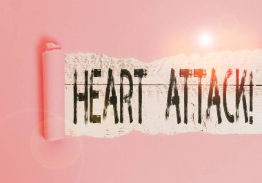 Handwriting text Heart Attack. Concept meaning sudden occurrence of coronary thrombosis resulting in death Cardboard which is torn in the middle placed above a wooden classic table.