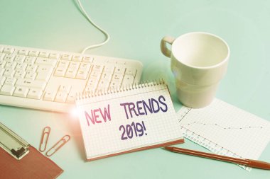Kelime yazma metni Yeni Eğilimler 2019. Kağıt mavi masa bilgisayarının klavye çalışma defteri çizelgesi notlarının oluşturulduğu genel yön için iş kavramı.