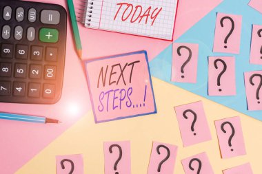 Kelime yazma metni Sonraki Adımlar. İşletme konsepti, ilkini bitirdikten sonra yaptığınız bir şey için. Matematiksel şeyler ve yazma ekipmanları Pastel renklerin üzerinde..