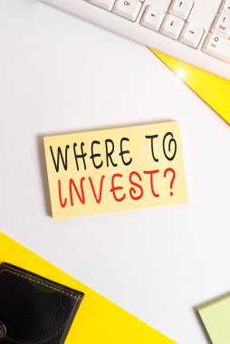 Soru Yatırılacak Yer adlı el yazısı metni. Finansal şemalara veya paylaşımlara parayı nereye koyduğunuzu soran kavram pc klavyeli düz bir masa üzerinde yatar ve metin iletileri için boşluk kağıdını kopyalar.