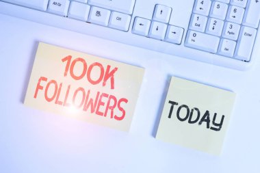 Metin işareti 100 bin takipçiyi gösteriyor. Instagram 'da birini takip eden bireylerin kavramsal fotoğraf sayısı boş fotokopi alanının üzerinde iş konseptiyle birlikte yatıyordu..