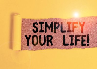 Kelime yazma metni Hayatınızı Basitleştirir. İşletme konsepti önemli şeylere odaklan ve bırak da daha azı için başkası endişelensin. Ortadan ikiye bölünmüş mukavva klasik ahşap bir masanın üzerine yerleştirilmiş..