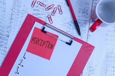 El yazısı algısı. Kavram, bireylerin duyusal izlenimlerini düzenlemeleri ve yorumlamaları anlamına gelir. Pano kağıdı yapışkan not, ataç, bardak, tahta arka plan..