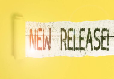 Yeni Sürüm 'ü gösteren metin işareti. Kavramsal fotoğraf, son zamanlarda haber değeri taşıyan bir şeyi duyuruyor. Karton, ortadan ikiye bölünmüş ve klasik ahşap bir masanın üzerine yerleştirilmiş..