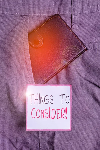 考慮すべきことを示すメモを書く。意思決定を行うために慎重に何かについて考える紹介ビジネス写真表記紙の近くのズボンのフロントポケット内の小さな財布. — ストック写真