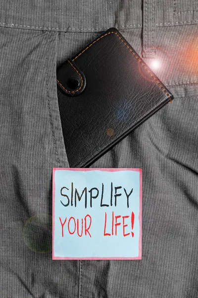 Writing note showing Simplify Your Life. Business photo showcasing focused on important and let someone else worry about less ones Small wallet inside trouser front pocket near notation paper. — Stock Photo, Image