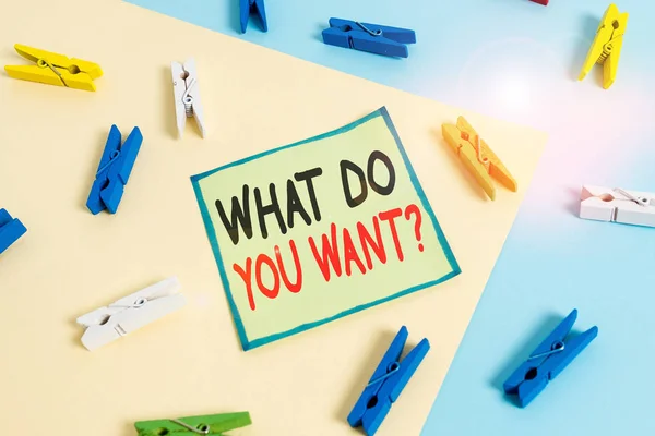 Conceptual hand writing showing What Do You Want Question. Business photo showcasing say or write in order to ask demonstrating about something Colored clothespin paper reminder with yellowblue backgr