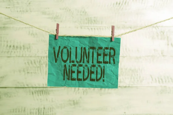 Text sign showing Volunteer Needed. Conceptual photo asking demonstrating to work for organization without being paid Clothesline clothespin rectangle shaped paper reminder white wood desk. — Stock Photo, Image
