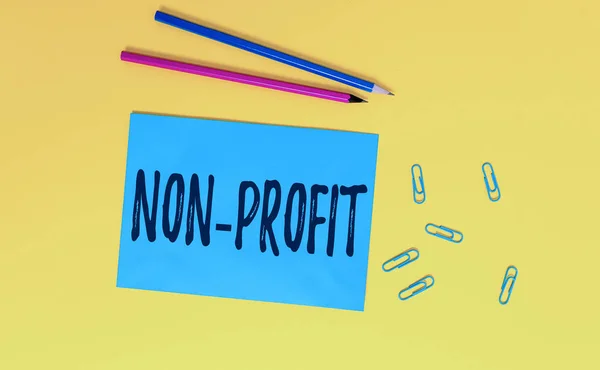 Begrebsmæssig håndskrift viser Non Profit. Business foto tekst ikke gør eller gennemført primært for at gøre profit organisation Blank papir ark besked påmindelse blyanter klip farvet baggrund . - Stock-foto