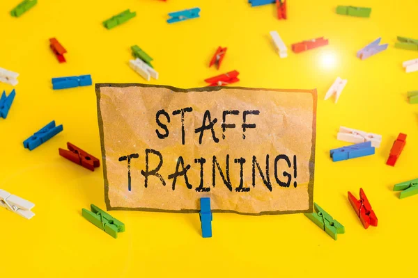 Handwriting text writing Staff Training. Concept meaning learn specific knowledge improve perforanalysisce in current roles Colored clothespin papers empty reminder yellow floor background office.