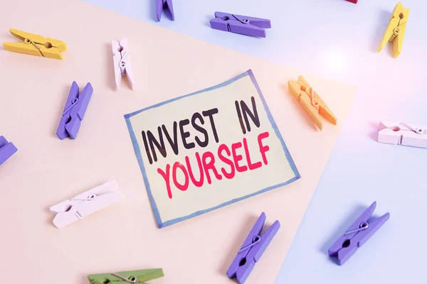 Ecriture conceptuelle montrant Invest In Yourself. Photo d'affaires mettant en valeur apprendre de nouvelles choses ou de nouveaux matériaux rendant ainsi votre beaucoup mieux Rappel de papier de pince à linge coloré avec fond bleu jaunâtre . — Photo