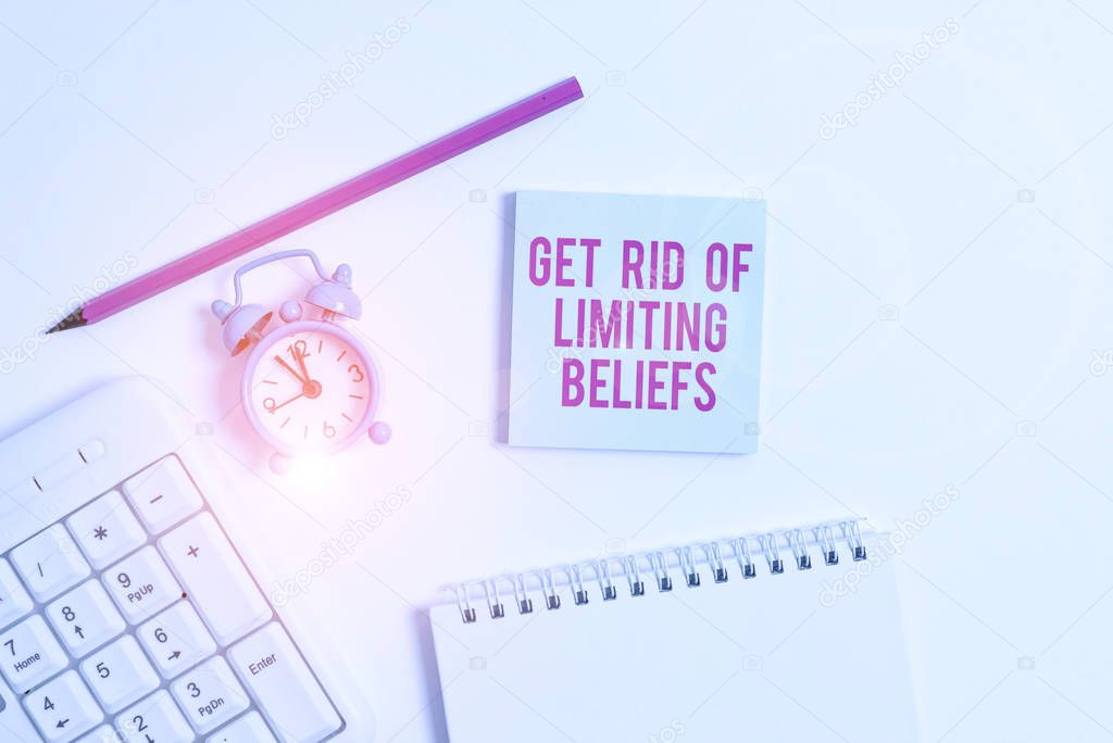 Handwriting text writing Get Rid Of Limiting Beliefs. Concept meaning remove negative beliefs and think positively White pc keyboard with empty note paper and pencil above white background.