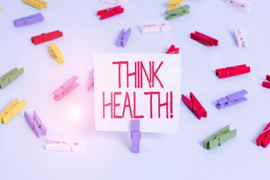 Think Health 'i gösteren bir not yazıyorum. Renkli çamaşır iğnesi kağıtlarının tamamen fiziksel ve sosyal sağlığını gösteren iş fotoğrafı mavi kattaki ofisin boş hatırlatıcısı.