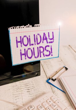 Holiday Hours 'u gösteren kavramsal el yazısı. Çalışma saatleri esnek çalışma saatleri altında çalışanlar için iş fotoğrafı metni Fazla mesaisi Klavye durağanlığının yanındaki siyah ekrana bantlanmış Not kağıdı.