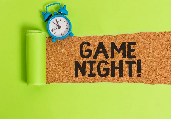 Conceptual hand writing showing Game Night. Business photo text usually its called on adult play dates like poker with friends Alarm clock and torn cardboard on a wooden classic table backdrop. — Stock Photo, Image