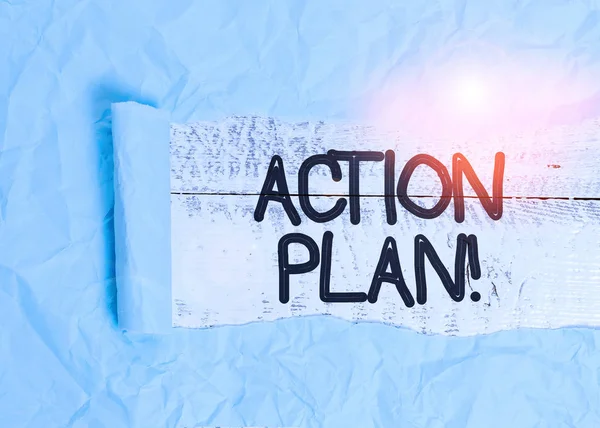 Text sign showing Action Plan. Conceptual photo proposed strategy or course of actions for certain time Cardboard which is torn in the middle placed above a wooden classic table.