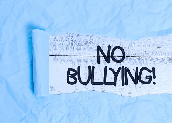 Text sign showing No Bullying. Conceptual photo stop aggressive behavior among children power imbalance Cardboard which is torn in the middle placed above a wooden classic table. — Stock Photo, Image