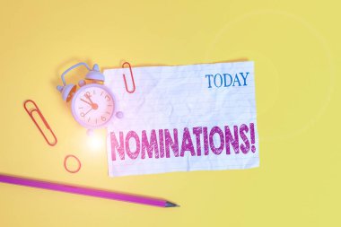 Kelime yazma adaylıkları. Ödül alarmlı saat kliplerine aday gösterilmek veya aday gösterilmek için iş konsepti ezilmiş lastik bant kalem renkli arka plan.