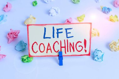 Handwriting text Life Coaching. Concept meaning demonstrating employed to help showing attain their goals in career Colored crumpled papers empty reminder white floor background clothespin.