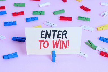 Enter To Win 'i gösteren kavramsal el yazısı. İş fotoğrafı sergisi ödüllü şans için bir şey takas ödüllü Renkli çamaşır iğnesi kağıtları boş hatırlatıcı pembe zemin ofisi.