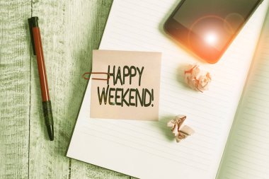 Mutlu Hafta Sonu tabelasını gösteriyor. Kavramsal fotoğraf güzel bir şey oldu ya da hayattan memnunlar. Kalın sayfalar dizüstü bilgisayar klasik ahşap zemin üstüne yerleştirilmiş..