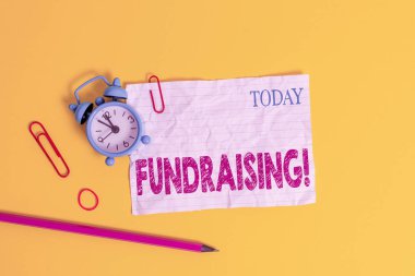 Kelime yazma yardım kampanyası. Hayır kurumu için finansal destek arayışı ya da alarm saati klipslerinin lastik bantlı arka planda ezilmesine neden olan iş konsepti.