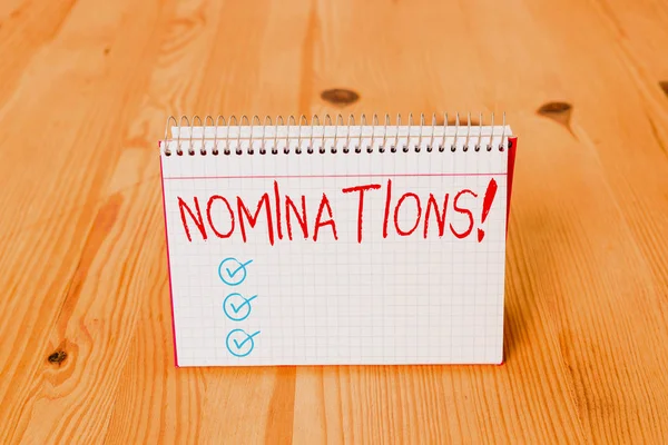 Handwriting text writing Nominations. Concept meaning action of nominating or state being nominated for prize Empty reminder wooden floor background spiral notebook groove slot office. — 스톡 사진