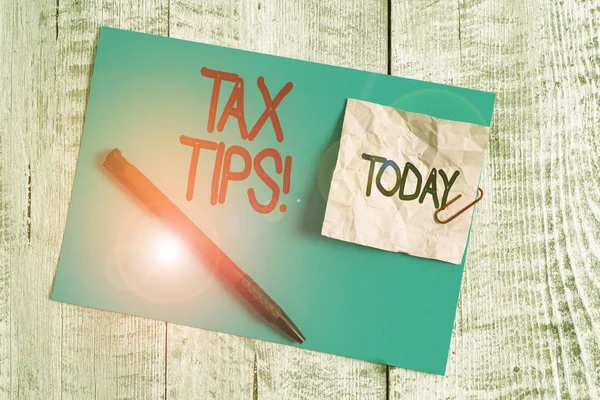 Text sign showing Tax Tips. Conceptual photo compulsory contribution to state revenue levied by government Wrinkle paper and cardboard plus stationary placed above wooden background.