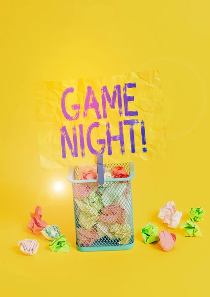 Conceptual hand writing showing Game Night. Business photo text usually its called on adult play dates like poker with friends Trash bin crumpled paper clothespin office supplies yellow.
