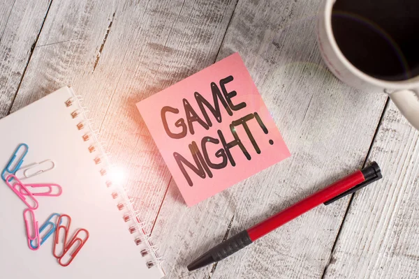Writing note showing Game Night. Business photo showcasing usually its called on adult play dates like poker with friends Stationary placed next to a cup of black coffee above the wooden table. — Stock Photo, Image