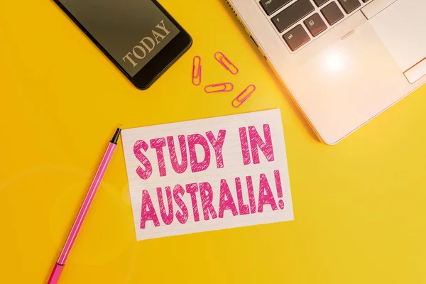 Word writing text Study In Australia. Business concept for going into foreign country order complete your studies Trendy open laptop smartphone marker paper sheet clips colored background. — Stock Photo, Image