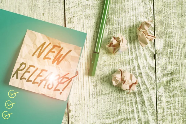 Text sign showing New Release. Conceptual photo announcing something newsworthy recent product Wrinkle paper and cardboard plus stationary placed above wooden background. — Stok fotoğraf