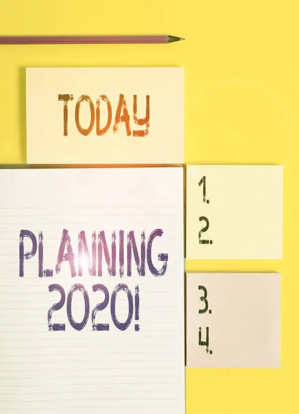 Текстове планування 2020 року. Концептуальний процес створення планів для чогось наступного року Кольорові порожні папери з місцем для копіювання на жовтій таблиці тла . — стокове фото