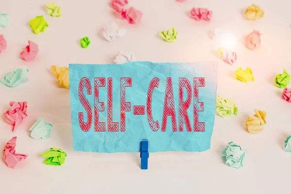 Conceptual hand writing showing Self Care. Business photo showcasing practice of taking action to preserve or improve ones own health Colored crumpled paper empty reminder white floor clothespin. — Stock Photo, Image