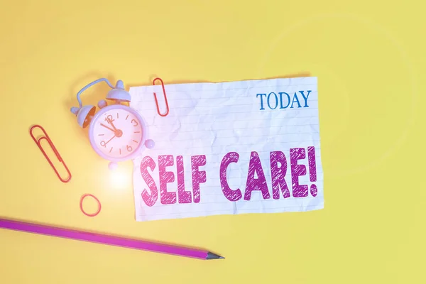 Написание текста Self Care. Бизнес-концепция для практики принятия мер по сохранению или улучшению собственного здоровья Будильник зажимы раздавленные записки резиновые ленты карандаш цветной фон . — стоковое фото