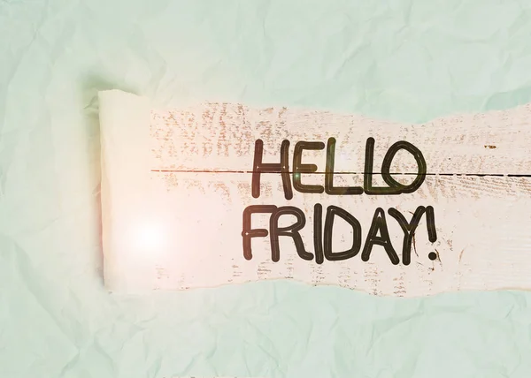 Text sign showing Hello Friday. Conceptual photo used to express happiness from beginning of fresh week Cardboard which is torn in the middle placed above a wooden classic table.