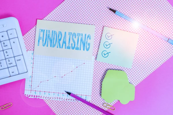 Handwriting text writing Fundraising. Concept meaning seeking to generate financial support for charity or cause Writing equipments and computer stuffs placed above colored plain table. — Stock Photo, Image