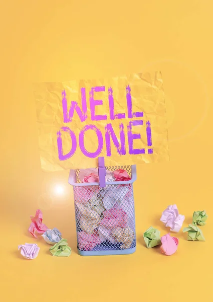 Conceptual hand writing showing Well Done. Business photo text used praising demonstrating or group for something have done good way Trash bin crumpled paper clothespin office supplies yellow.