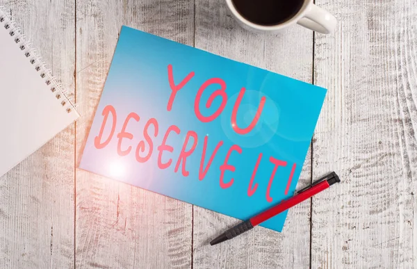 Text sign showing You Deserve It. Conceptual photo should have it because of their qualities or actions Stationary placed next to a cup of black coffee above the wooden table.