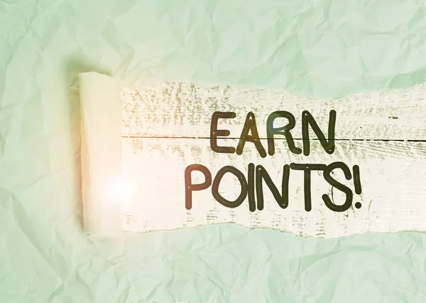 Text sign showing Earn Points. Conceptual photo collecting scores in order qualify to win big prize Cardboard which is torn in the middle placed above a wooden classic table.